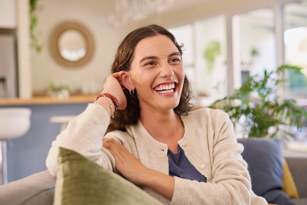 A smiling adult seated in a bright room.